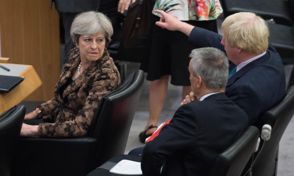 Theresa May watches as Boris Johnson points at the UN