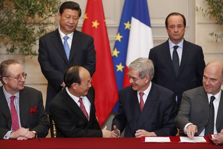 Philippe Varin (2nd R), outgoing Chief Executive Officer of French carmaker PSA Peugeot Citroen, shakes hands with Xu Ping (2nd L), chairman of Dongfeng Motor Group Company, as French Finance Minister Pierre Moscovici (R) and Robert Peugeot (L), director of the board of French carmaker PSA Peugeot Citroen, attend a signing ceremony at the Elysee Palace in Paris in this March 26, 2014 file photo. REUTERS/Benoit Tessier/Files