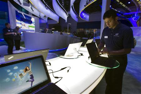 Raman Chari prepares a display of convertible Ultrabooks at the Intel booth prior to the opening of the Consumer Electronics Show (CES) in Las Vegas in this January 8, 2013 file photo. REUTERS/Steve Marcus/Files