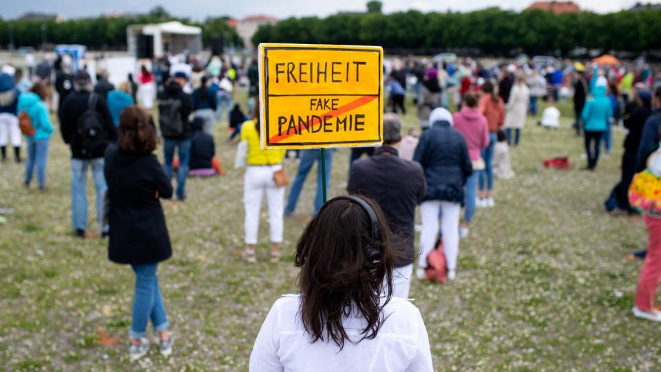 "Freiheit/Fake-Pandemie": Eine Teilnehmerin einer Demonstration mit einem Protestschild in München.