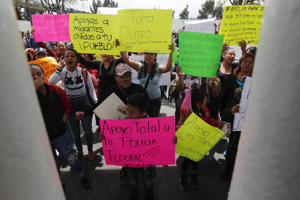 Family members of Mexican federal police gather outside a police command center in the Iztapalapa borough, in Mexico City, Wednesday, July 3, 2019, to protest against plans to force federal police into the newly formed National Guard. The protest comes as the government is officially starting to deploy the National Guard to several states to fight crime and control immigration. (AP Photo/Marco Ugarte)