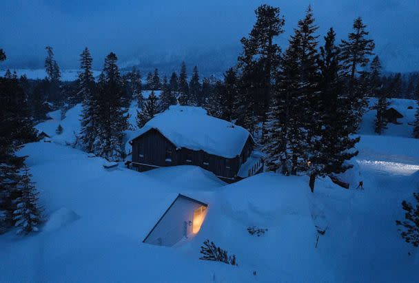 PHOTO: As night falls, a person shovels snow in the Sierra Nevada mountains, March 29, 2023 in Mammoth Lakes, Calif. (Mario Tama/Getty Images)