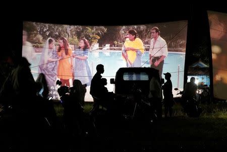 People watch a film during a wedding party in Bogor, Indonesia, March 19, 2017. REUTERS/Beawiharta/Files