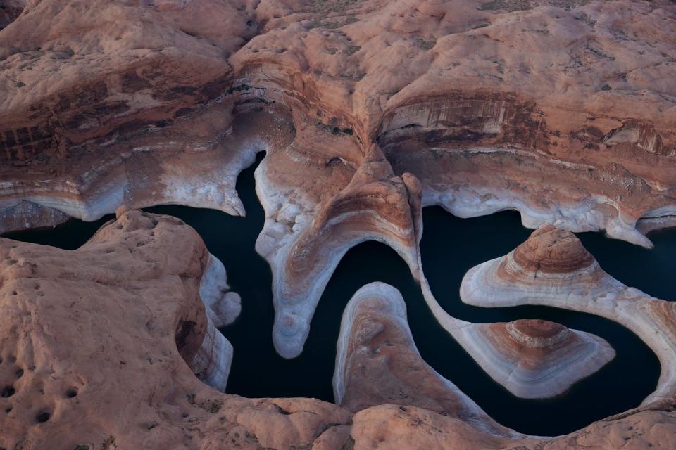 <span class="caption">The ‘bathtub ring’ on Lake Powell, one of the nation’s largest reservoirs, attests to its falling water level over two decades of drought in Arizona. The Colorado River reservoir is crucial for water supplies and hydropower.</span> <span class="attribution"><a class="link " href="https://www.gettyimages.com/detail/news-photo/the-tall-bleached-bathtub-ring-is-visible-on-the-rocky-news-photo/1325430487" rel="nofollow noopener" target="_blank" data-ylk="slk:Justin Sullivan/Getty Images;elm:context_link;itc:0;sec:content-canvas">Justin Sullivan/Getty Images</a></span>