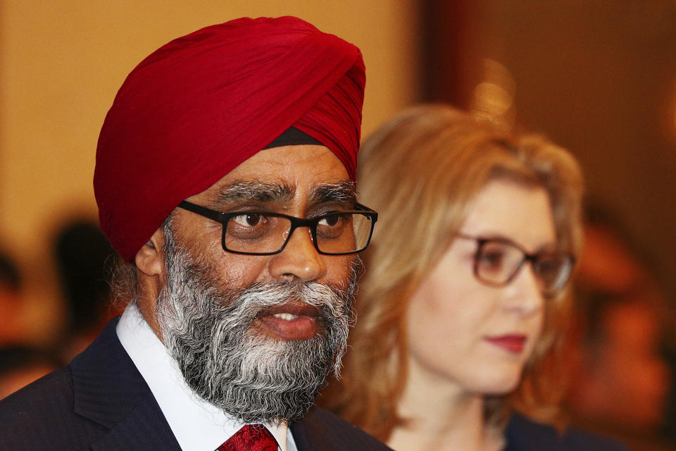 Canadian Minister of National Defense Harjit Singh Sajjan, left, arrives for the opening dinner of the 18th International Institute for Strategic Studies (IISS) Shangri-la Dialogue, an annual defense and security forum in Asia, in Singapore, Friday, May 31, 2019. (AP Photo/Yong Teck Lim)