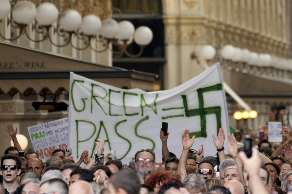 People stage a protest against the "green pass" in Milan, Italy, Saturday, July 24, 2021. Italy's government approved a decree ordering the use of the so-called "green" passes starting on Aug. 6. To be eligible for a pass, individuals must prove they have received at least one vaccine dose in the last nine months, recovered from COVID-19 in the last six months or tested negative in the previous 48 hours. The passes will be needed to dine at tables inside restaurants or cafes, to attend sports events, town fairs and conferences, and to enter casinos, bingo parlors and pools, among other activities. according to officials. (AP Photo/Antonio Calanni)