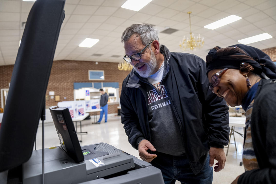 A man shares a laugh with a poll worker as he casts his vote at Cayce United Methodist Church