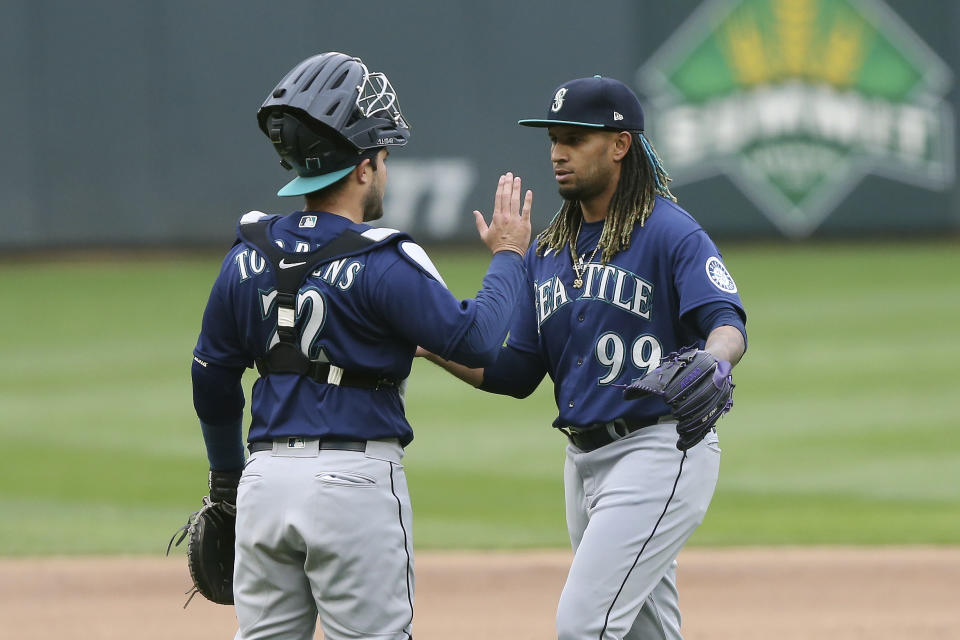 Seattle Mariners relief pitcher Keynan Middleton (99) high-fives catcher Luis Torrens (22) after their 4-3 win in the 10th inning of a baseball game against the Minnesota Twins, Saturday, April 10, 2021, in Minneapolis. (AP Photo/Stacy Bengs)