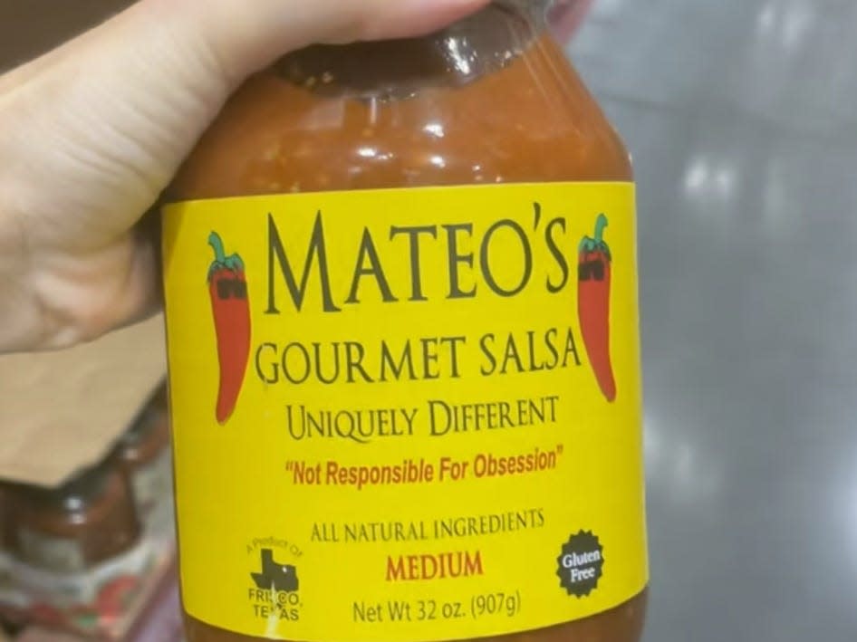 hand holding jar of salsa at costco