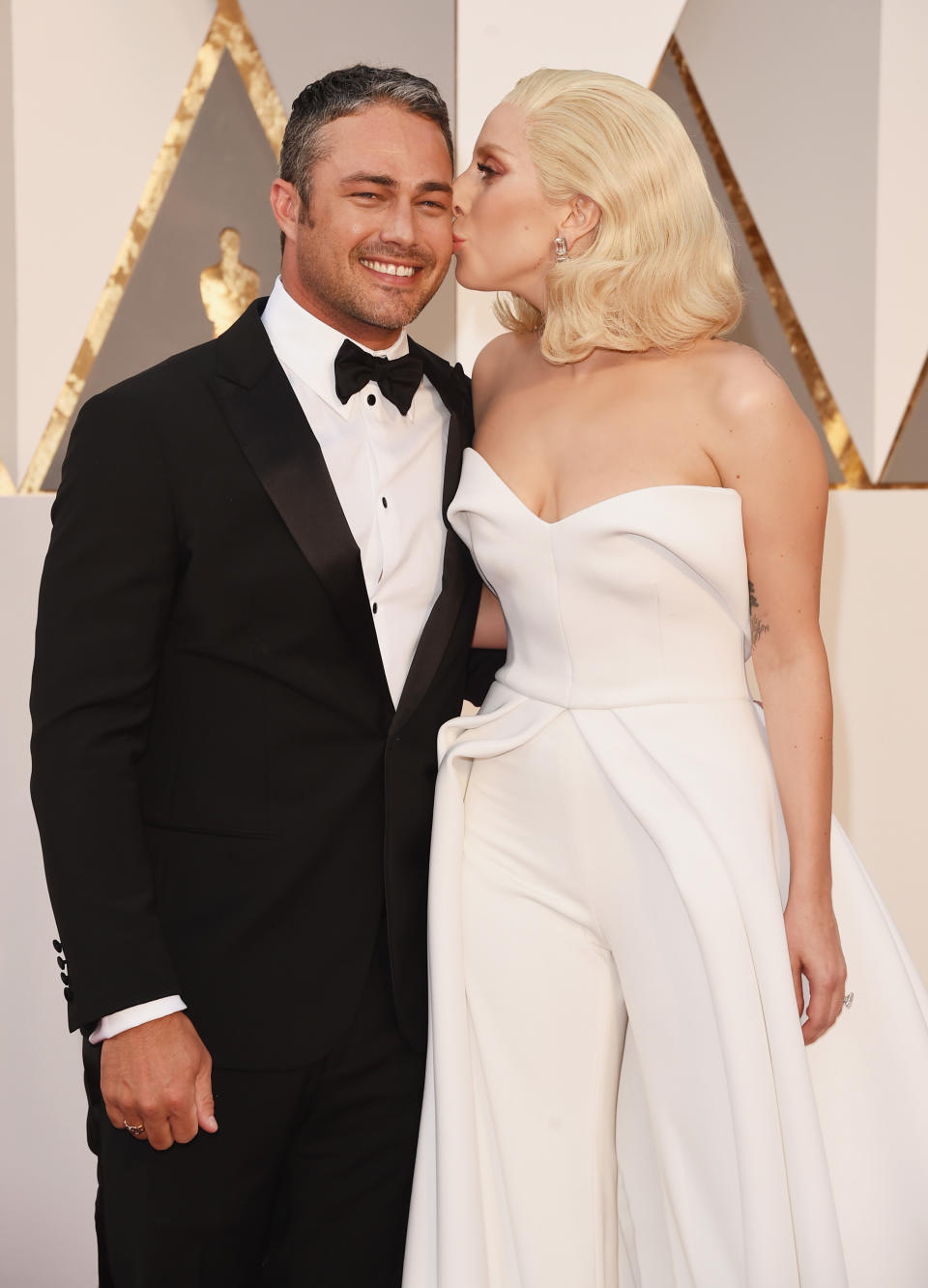 Ein Küsschen für ihren Liebsten: Lady Gaga drückt Taylor Kinney einen herzhaften Schmatzer auf. Auch wenn die Künstlerin keinen Oscar für den besten Song bekam, ihre Performance des Lieds "Till It Happens To You" bei den Academy Awards war ein voller Erfolg und rührte so manchen zu Tränen. Besonders schön war auch ihr weißer Retro-Dress. (Bild-Copyright: Getty Images/Jason Merritt)