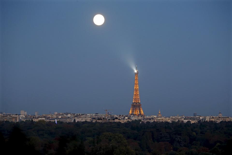 A super moon rises in the sky near the Eiffel tower as seen from Suresnes, Western Paris, France, September 27, 2015. The astronomical event occurs when the moon is closest to the Earth in its orbit, making it appear much larger and brighter than usual. REUTERS/Charles Platiau