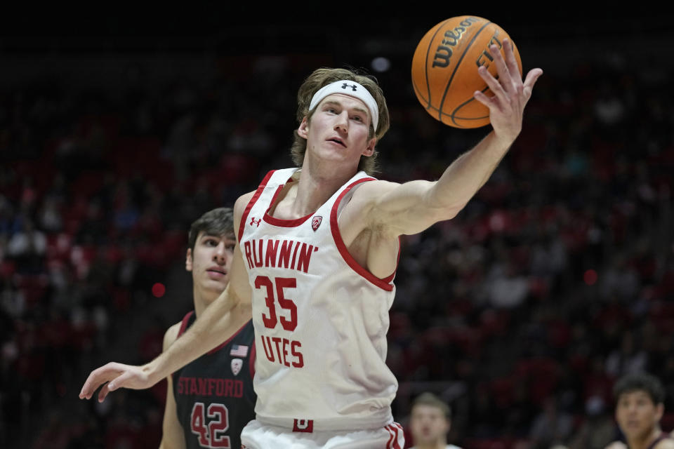 Utah center Branden Carlson (35) reaches for a rebound as Stanford forward Maxime Raynaud (42) looks on during the second half of an NCAA college basketball game, Thursday, Feb. 2, 2023, in Salt Lake City. (AP Photo/Rick Bowmer)