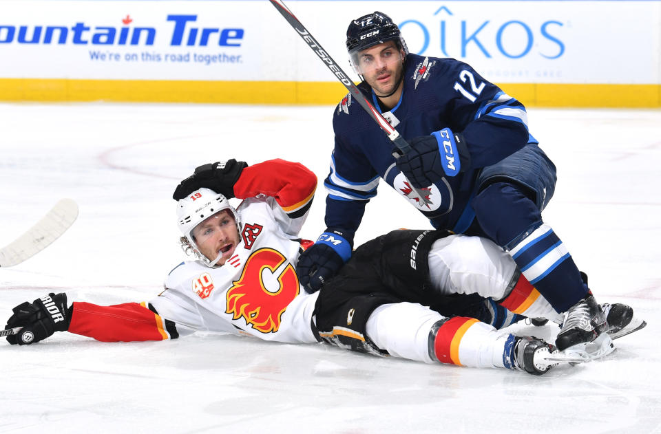 EDMONTON, ALBERTA - AUGUST 04: Dylan DeMelo #12 of the Winnipeg Jets puts keeps Matthew Tkachuk #19 of the Calgary Flames down during the third period of Game Three of the Western Conference Qualification Round at Rogers Place on August 04, 2020 in Edmonton, Alberta. (Photo by Andy Devlin/NHLI via Getty Images)