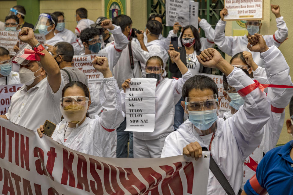 FILE PHOTO: Health workers wearing hazmat suits raise their fists as they protest their unreleased benefits amid the pandemic, outside the Department of Health headquarters on September 1, 2021 in Manila, Philippines. (Photo: Ezra Acayan/Getty Images)