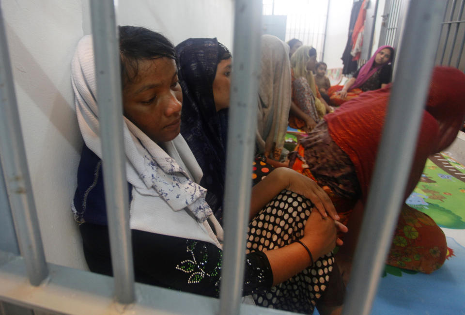 FILE- In this June 12, 2019, file photo, Rohingya refugees sit behind bars at a police station in Satun province, southern Thailand after Thai officials say they have discovered 65 ethnic Rohingya Muslim refugees who were shipwrecked and stranded in southern Thailand. A U.N. report says organized crime syndicates in Southeast Asia are flourishing in the illegal trafficking of drugs, wildlife, counterfeit goods and people.(AP Photo/Sumeth Panpetch, File)