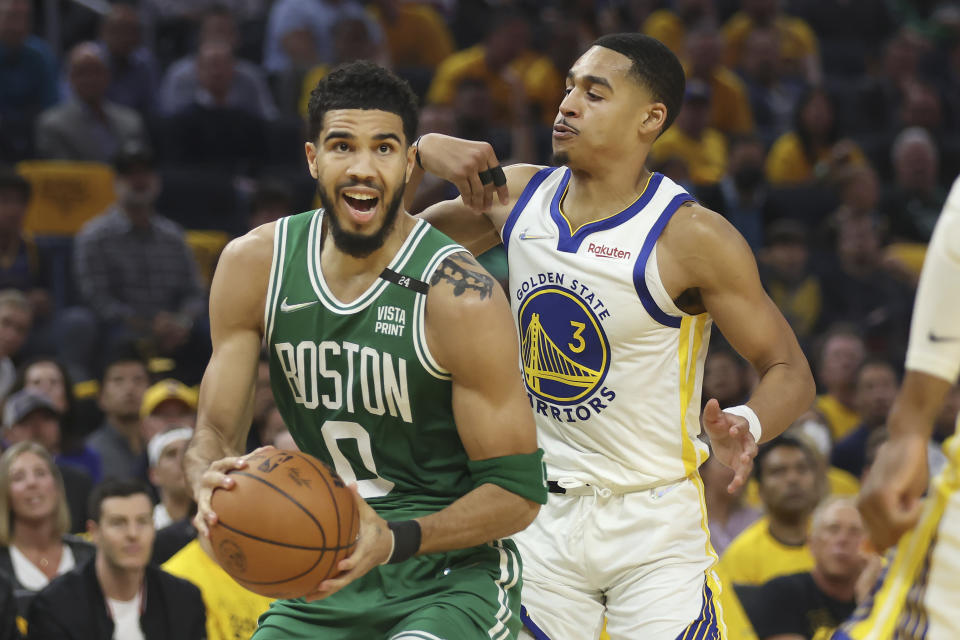 Boston Celtics forward Jayson Tatum (0) drives to the basket against Golden State Warriors guard Jordan Poole (3) during the first half of Game 1 of basketball's NBA Finals in San Francisco, Thursday, June 2, 2022. (AP Photo/Jed Jacobsohn)