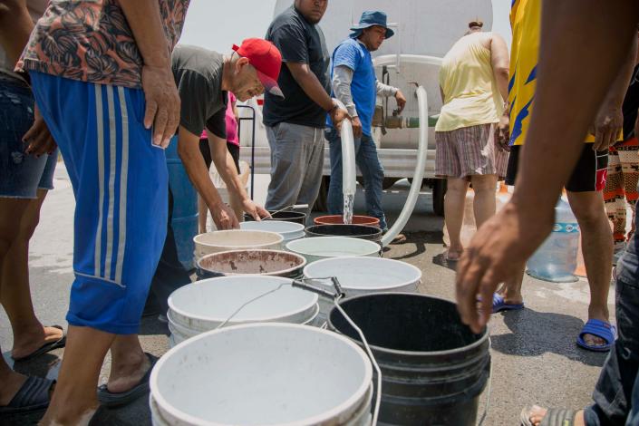 Residents queue to collect clean water from a tanker truck in Garcia municipality, northwest of the Monterrey metropolitan area, Nuevo Leon State, Mexico, on June 8, 2022.