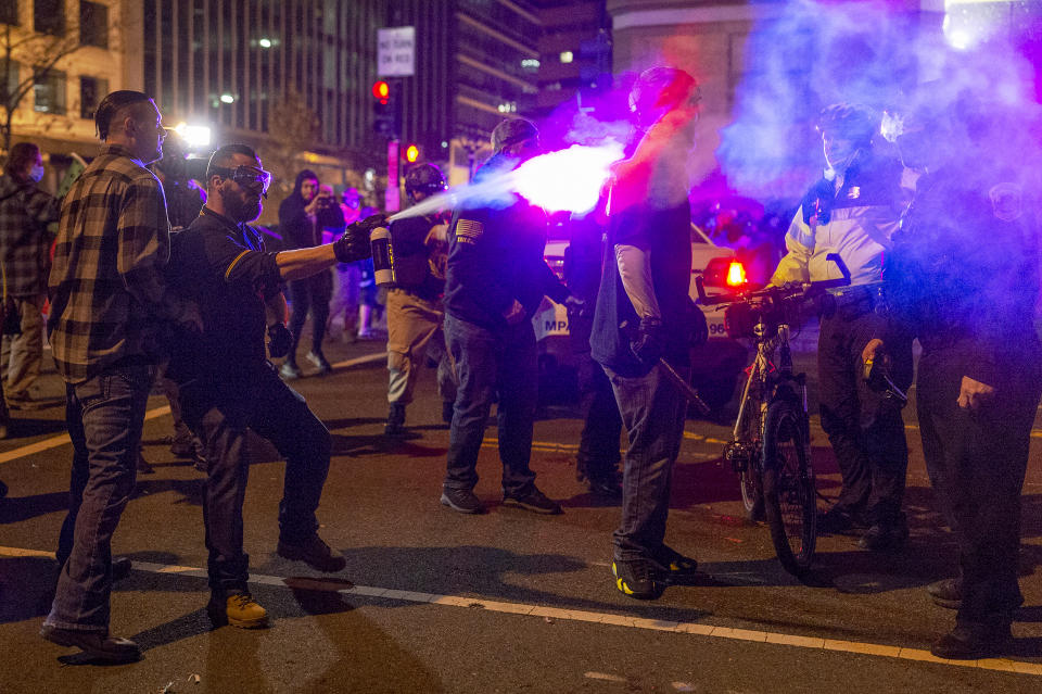 A member of the Proud Boys sprays a police officer with a chemical agent in downtown Washington as the group clashed continuously with counter-protesters on the evening of the second Million MAGA March in on Dec. 12, 2020. (Craig Hudson / The Washington Post via Getty Images file)