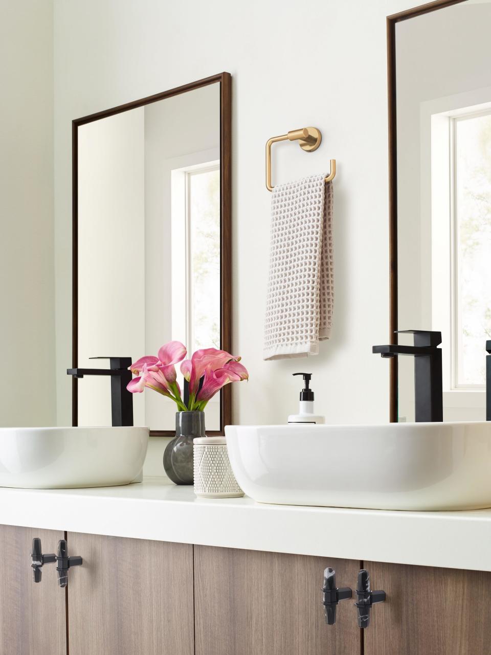 the gold hand towel holder hanging in the middle of double sinks