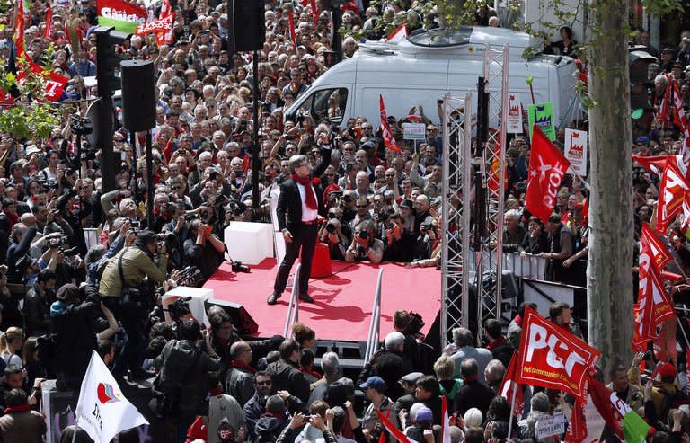 Jean-Luc Melenchon (C), leader of Front de Gauche (Left Front) left wing party raises his fist as he gives a speech on stage on May 5, 2013 in Paris, during a demonstration