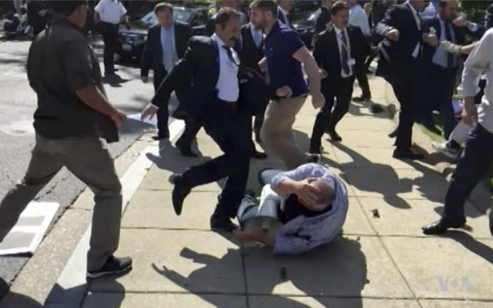 In this frame grab from video provided by Voice of America, members of Turkish President Recep Tayyip Erdoganâs security detail are shown violently reacting to peaceful protesters during Erdogan’s trip last month to Washington. House Republican and Democratic lawmakers are expected to approve overwhelmingly a resolution that calls for members of Erdoganâs security detail who were involved in the incident to be brought to justice. The vote is slated for Tuesday evening. (Voice of America via AP)