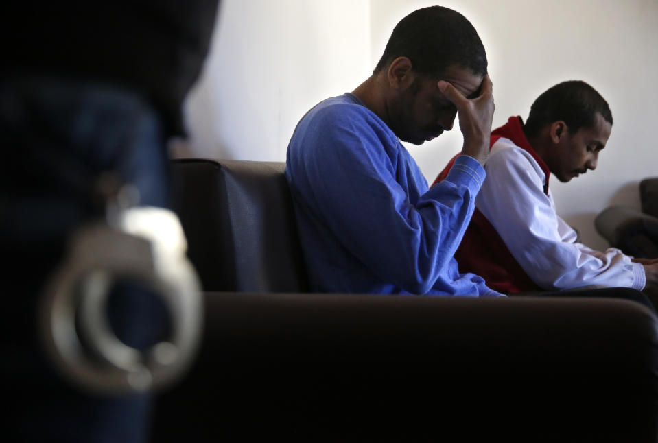 FILE - In this March 30, 2018, file photo, Alexanda Amon Kotey, left, and El Shafee Elsheikh, who were allegedly among four British jihadis who made up a brutal Islamic State cell dubbed "The Beatles," sit on a sofa during an interview with The Associated Press at a security center in Kobani, Syria. (AP Photo/Hussein Malla, File)