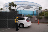 A minivan enters the loading dock area of the Long Beach Convention Center, in Long Beach, Calif., Thursday, April 22, 2021, where migrant children found at the U.S.-Mexico border without a parent will be temporarily housed. The beds are in pods of 30. The center is able to house up to 1,000 children and the first children are expected to arrive Thursday afternoon. (AP Photo/Jae C. Hong)