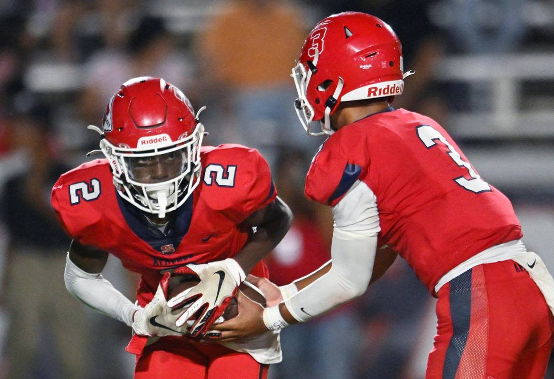 Sanger’s Carlos Young, left receives the handoff against Dinuba in the second half Friday, Aug. 18, 2023 in Sanger. Final score, Sanger 41, Dinuba 7. ERIC PAUL ZAMORA/ezamora@fresnobee.com