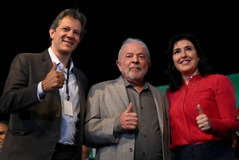 Luiz Inacio Lula da Silva, con el futuro ministro de Economía, Fernando Haddad, y la de Planificación, Simone Tebet, este jueves en Brasilia. (EVARISTO SA / AFP)