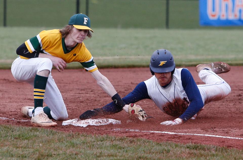 Cameron Allen, right, of Ellet is safe at third base past the tag of Devin James of Firestone during their game at Ellet High School Friday.