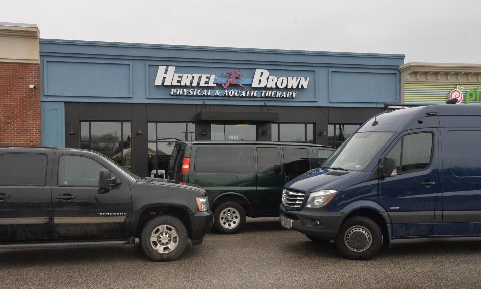 FBI and other law enforcement agencies parked vans outside the West Erie Plaza main office of Hertel & Brown Physical & Aquatic Therapy on Feb. 23, 2021. Investigators were searching the office and other Hertel & Brown offices in a probe that led to a 21-defendant indictment on Nov. 9, 2021.