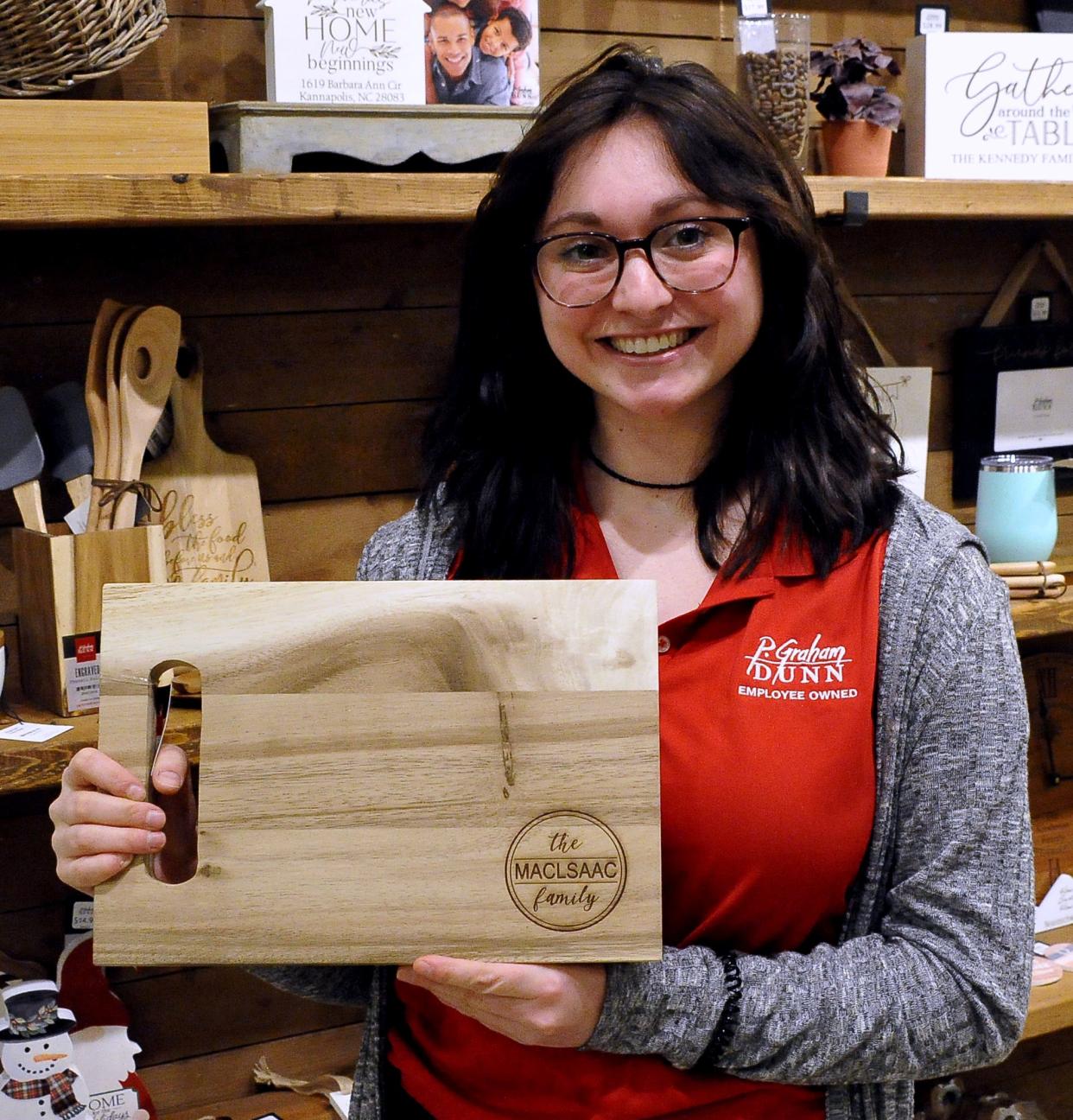 Kara Swartzentruber holds an engraved cutting board for sale at P. Graham Dunn in Dalton.
