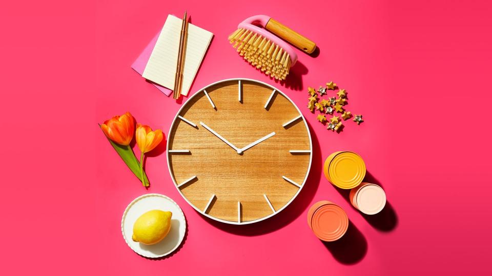 wooden clock with flowers cans notepad and lemon on a plate