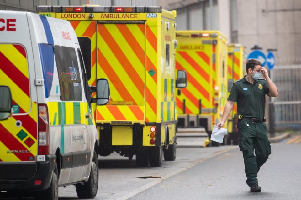 A paramedic walks past a line of ambulances  (PA )