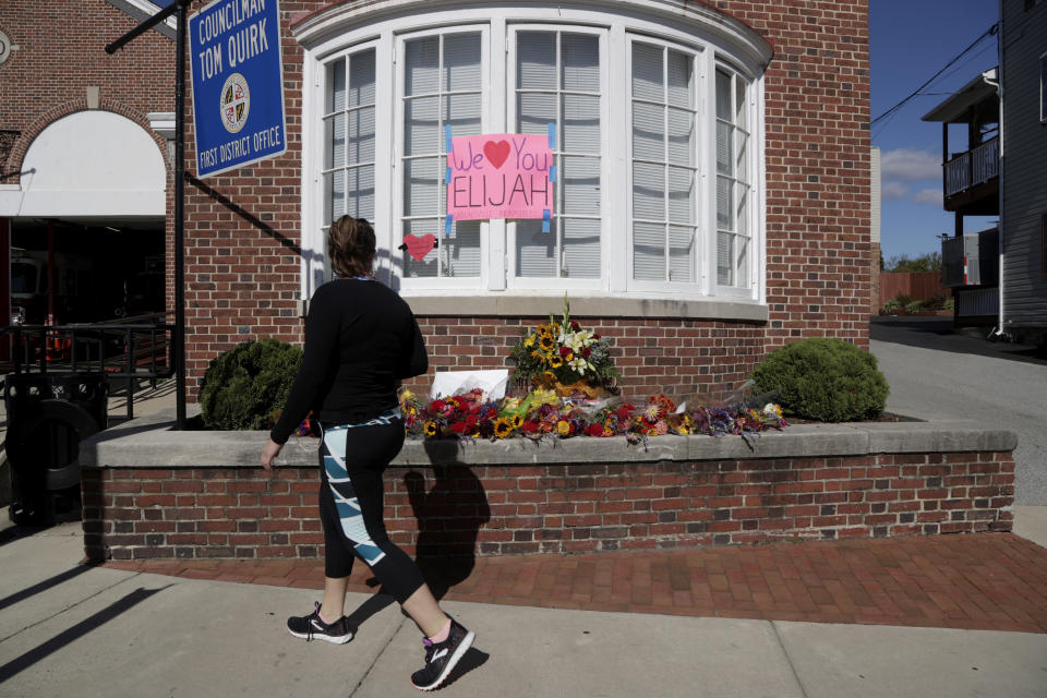 A woman looks at flowers and messages outside of the office of the late U.S. Rep. Elijah Cummings, D-Md., a day after the congressman died Friday, Oct. 18, 2019, in Catonsville, Md. Many faith leaders, activists and politicians in Baltimore have one thing in common: They were mentored by Cummings. Cummings, who died at 68, inspired and advised others, sharing his political wisdom. (AP Photo/Julio Cortez)