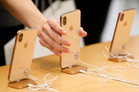 People look at iPhones at the World Trade Center Apple Store during a Black Friday sales event in Manhattan, New York City