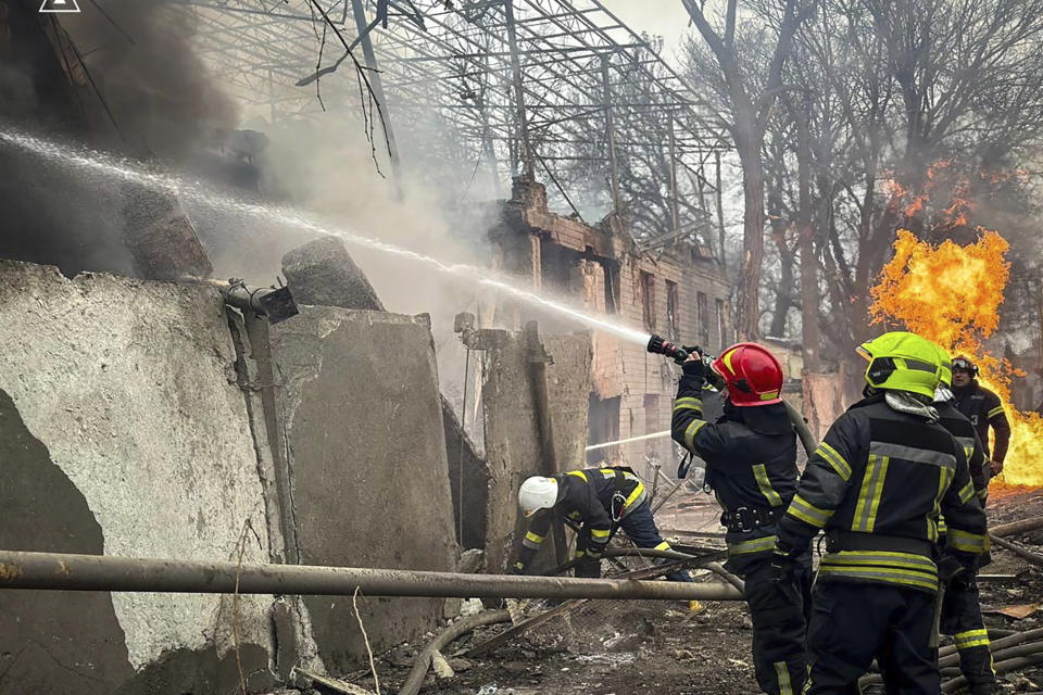 In this photo provided by the Ukrainian Emergency Service, emergency services firefighters extinguish a fire at the scene of a Russian attack in Odesa, Ukraine, Friday, March 15, 2024. A Russian missile strike on Odesa in southern Ukraine on Friday killed at least 14 people and injured 46 others, local officials said. (Ukrainian Emergency Service via AP)