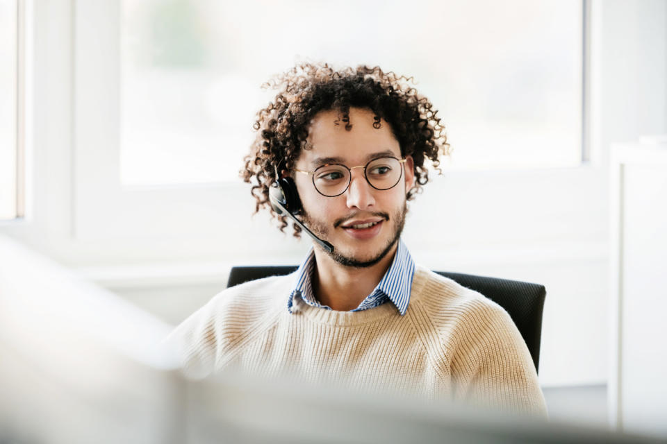 Man in a white room with a headset on