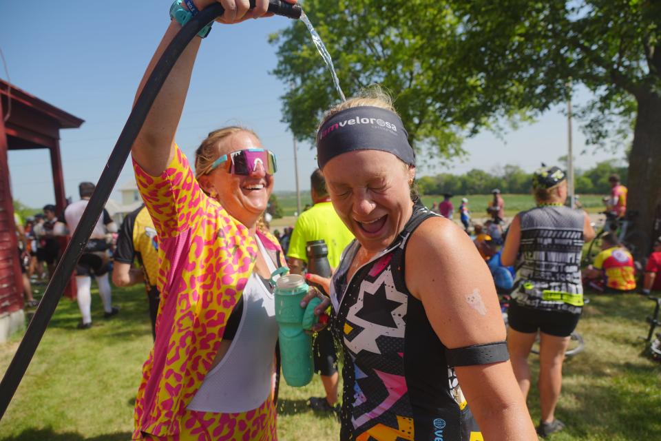 Janae Ingles of Ankeny pours water on Krystyn Williams of Des Moines at the Iowa Craft Beer Tent as RAGBRAI 50 rolls toward Coralville, its final overnight stop, on Friday.