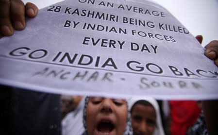 A Kashmiri girl displays a placard as she shouts slogans at a protest in Srinagar