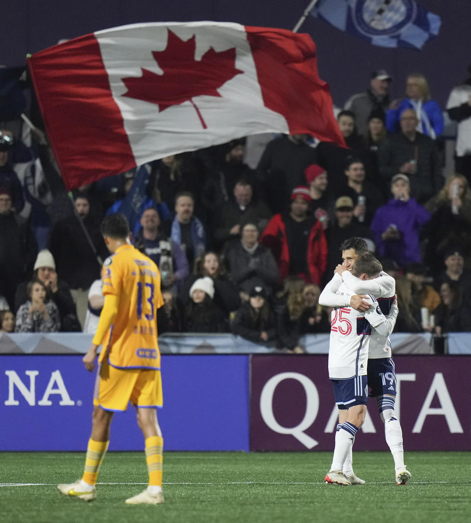 Vancouver Whitecaps' Damir Kreilach, right, and Ryan Gauld celebrate Kreilach's goal, while Tigres UANL's Diego Reyes walks on the pitch during the first half of a CONCACAF Champions Cup soccer match Wednesday, Feb. 7, 2024, in Langford, British Columbia. (Darryl Dyck/The Canadian Press via AP)