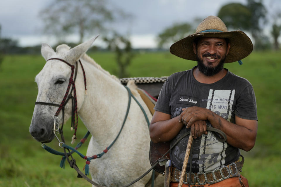 Cowboy Alexandre Rodrigues speaks after finishing work weighing and marking calves, in a corral at the Fazenda Itaituba, a farm in the municipality of Bujari, near the city of Rio Branco, Acre state, Brazil, Tuesday, May 23, 2023. (AP Photo/Eraldo Peres)