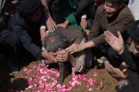 <p>An elderly father (C) mourns at the grave of his son in Kabul on October 12, 2016, after he was killed in an attack by gunmen inside the Karte Sakhi shrine late on October 11.<br> Grieving worshippers on October 12 described desperately trying to shelter their children against a hail of gunfire in Kabul that killed at least 18 people gathering to mark Ashura, one of the most important festivals of the Shiite calendar. (Photo: Shah Marai/ AFP/Getty Images) </p>