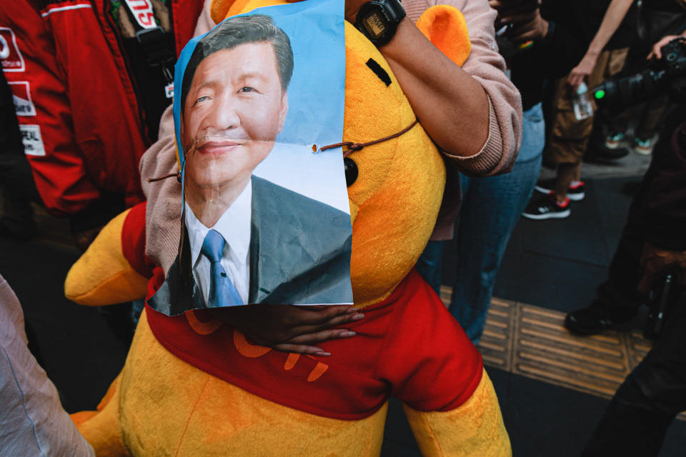 A protester holds a poster of Xi Jinping and a Pooh plush during a demonstration in Bangkok, where the Chinese leader was attending APEC in November 2022.<span class="copyright">Varuth Pongsapipatt—SOPA/LightRocket/Getty Images</span>