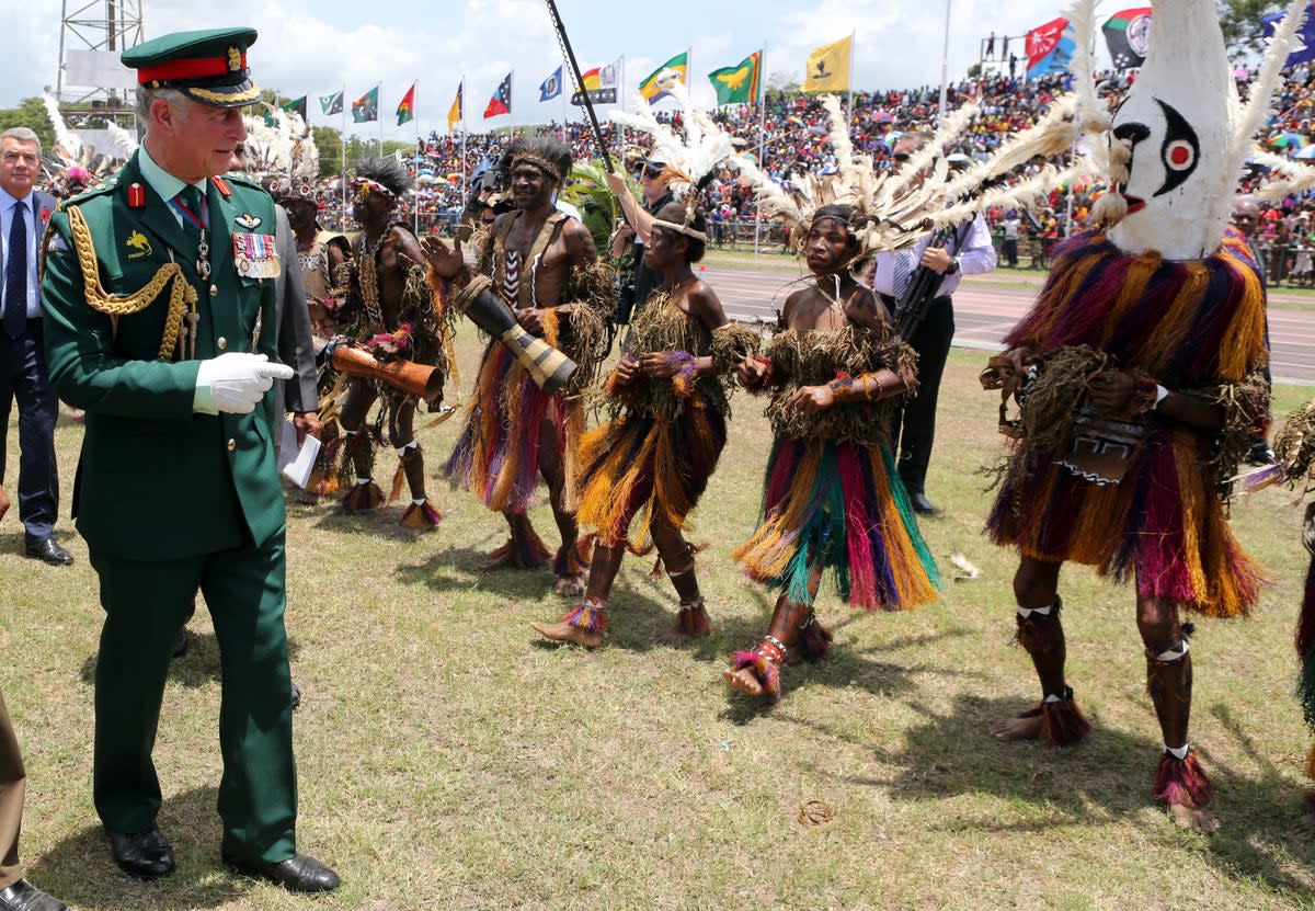 The then Prince of Wales meets dancers dressed in traditional dress during a visit to the Sir John Guise Stadium in Papua New Guinea in 2012 (Chris Radburn/PA) (PA Archive)