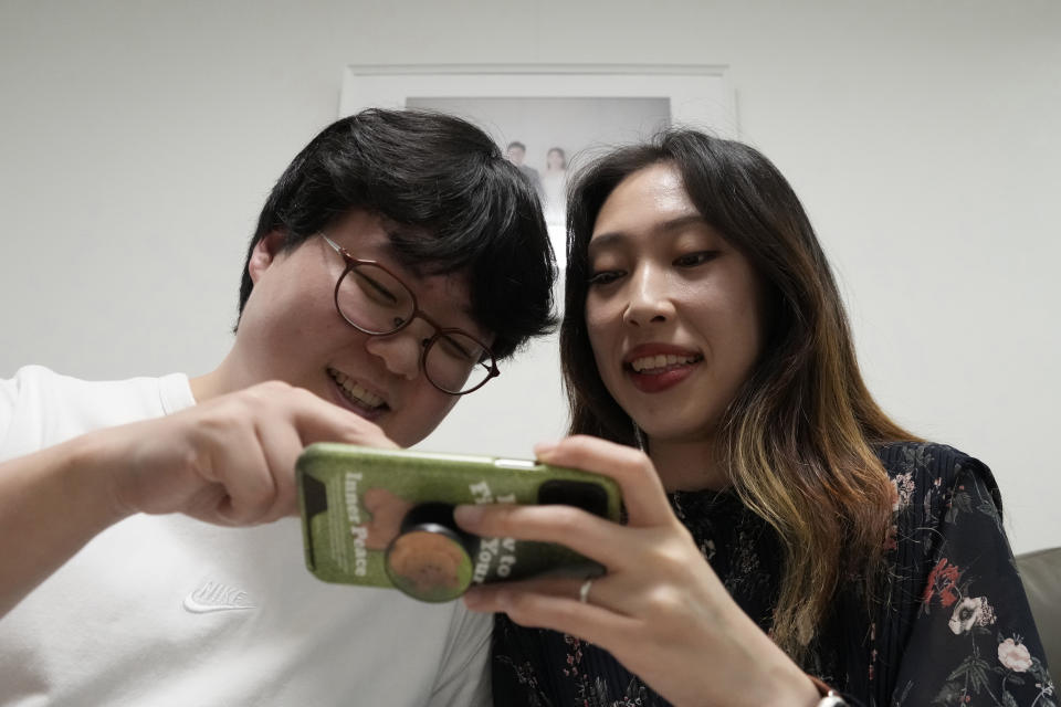 Yoo Young Yi and her husband Jo Jun Hwi watch their YouTube channel at their home in Seoul, South Korea, Sunday, Oct. 2, 2022. Many young people in South Korea have chosen not to marry or have children, citing a change of views toward a marriage and family life and uncertainty of their future. (AP Photo/Ahn Young-joon)