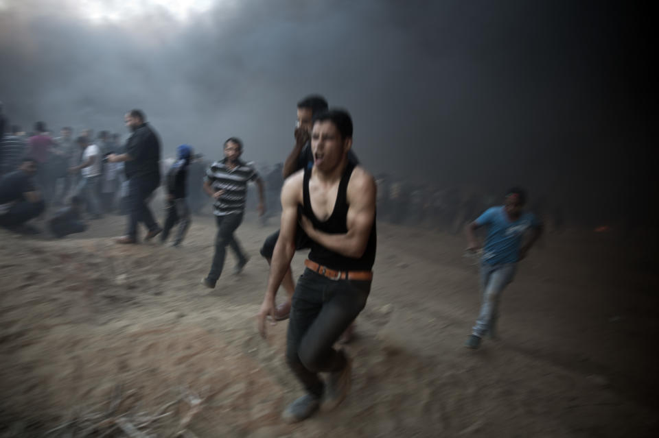 A wounded Palestinian protester runs out towards the ambulances during a protest at the Gaza Strip's border with Israel, Friday, Oct. 12, 2018. (AP Photo/Khalil Hamra)