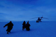 Children from the indigenous community "Yamb To" (Long Lake) run to a helicopter carrying local electoral commission officials during the early voting in remote areas ahead of the presidential election, at a reindeer camping ground, about 450 km northeast of Naryan-Mar, in Nenets Autonomous District, Russia, March 1, 2018. REUTERS/Sergei Karpukhin