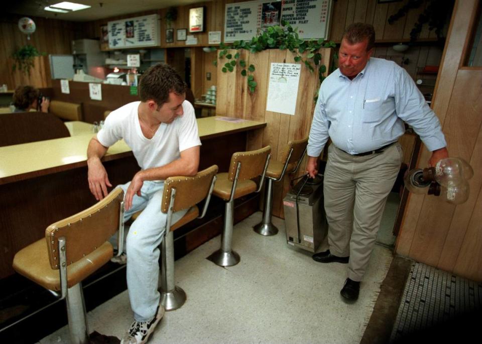 8/21/97 GAYLE SHOMER/Staff Donald Thrift of Standard Coffee Service removes the coffee maker and empty pots from the lunch counter. The parents of Mike Katergaris (left) bought some of the restaurant equipment.