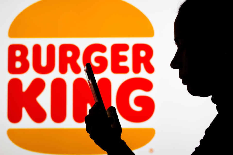 BRAZIL - 2022/04/18: In this photo illustration the Burger King logo seen in the background of a silhouette woman holding a mobile phone. (Photo Illustration by Rafael Henrique/SOPA Images/LightRocket via Getty Images)